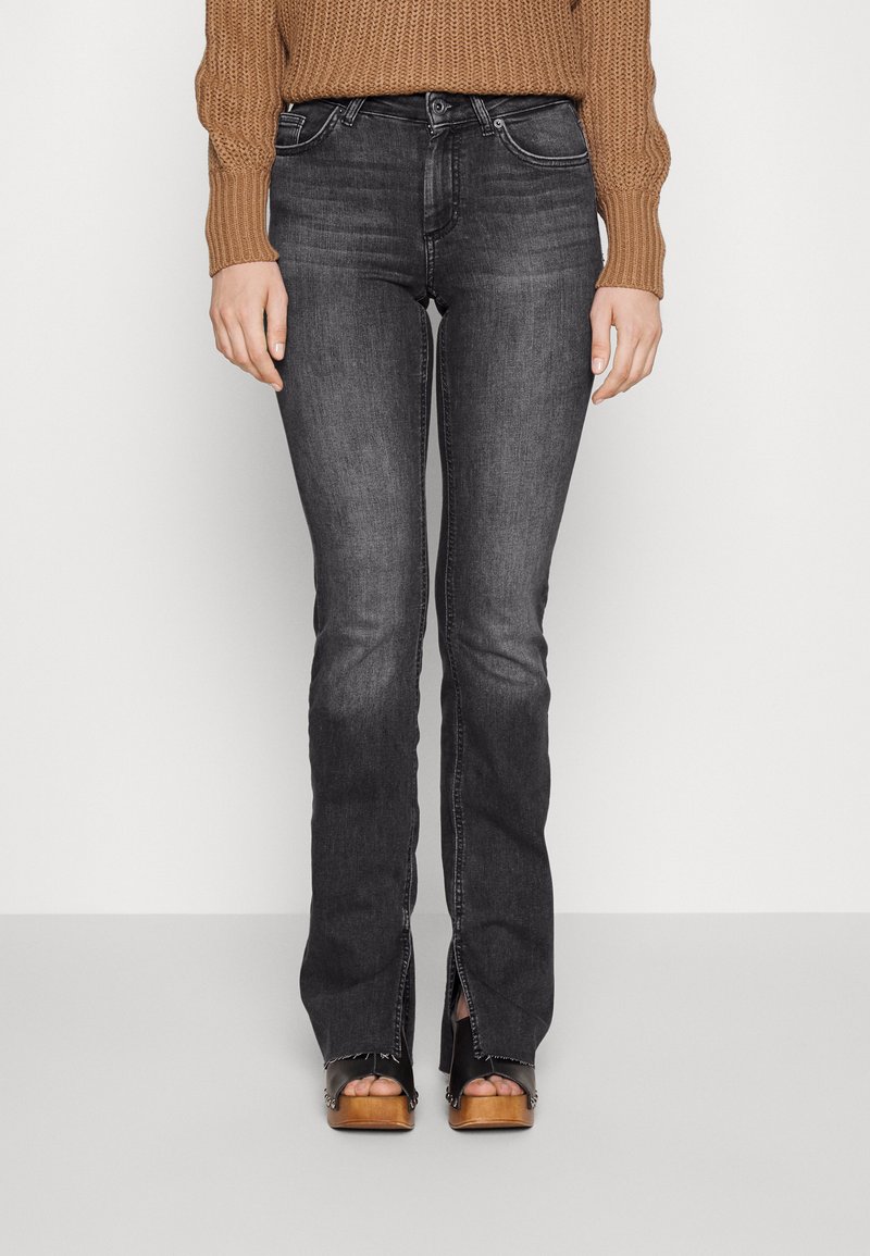 Donkergrijze jeans met een getailleerde taille, lichte flare aan de onderkant en details op de voorzakken. De stof heeft een gladde textuur en subtiele vervaging.