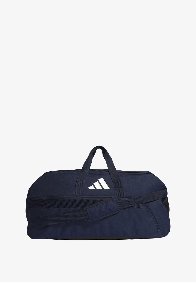 Navy blue duffel bag with adjustable shoulder strap, two carry handles, and white logo detail. Durable fabric with zippered pocket.