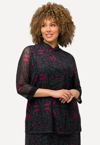 Blusa nera trasparente con maniche a tre quarti, caratterizzata da un motivo floreale nei toni del rosa e dell'azzurro. Collo alto, texture morbida.