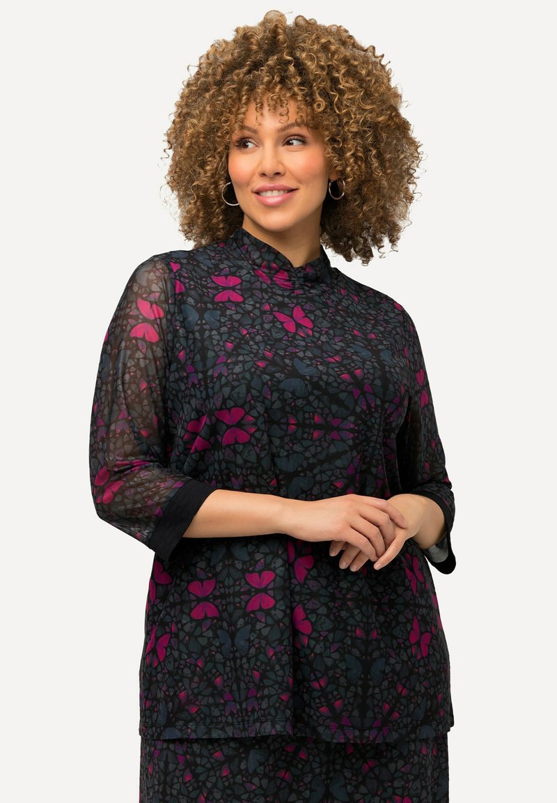 Blusa nera trasparente con maniche a tre quarti, caratterizzata da un motivo floreale nei toni del rosa e dell'azzurro. Collo alto, texture morbida.