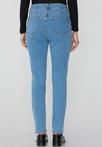 Světlé modré džíny, slim fit s vysokým pasem, s dvěma zadními kapsami a vybledlou strukturou. Lem je rovný a nedokončený.