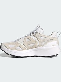 White and beige athletic shoe with mesh upper, curved sole, textured accents, and black tread on the bottom for grip.