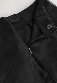 Schwarze Jacke mit Reißverschluss, Druckknopfdetails und glatter Stoffoberfläche. Verfügt über eine Tasche mit Reißverschluss und ein schlichtes Innenfutter.