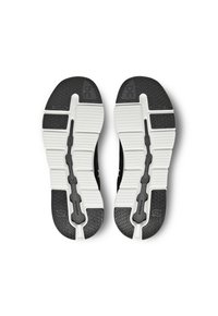 Zwarte sportschoenen met een gestructureerde rubberen zool, een witte tussenzool en opvallende patronen voor grip. Twee-kleurig ontwerp.