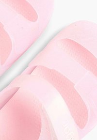 Růžové sandály s hladkým, lesklým povrchem. Mají dva široké popruhy, texturovanou stélku a design na obutí.