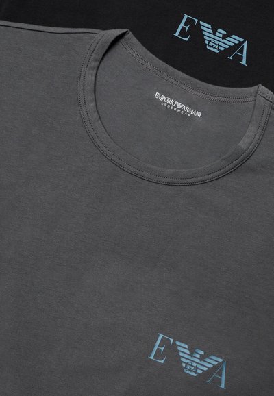 Sivé tričko Emporio Armani s okrúhlym výstrihom s modrým logom "E A" a emblémom orla tlačeným blízko lemu, zobrazené s značkovým tmavým obalom.