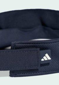 Granatowa opaska na głowę z miękkiej tkaniny, z metką z logo i bezpiecznym zapięciem na rzep. Zaprojektowana z myślą o komforcie i stabilności podczas aktywności.