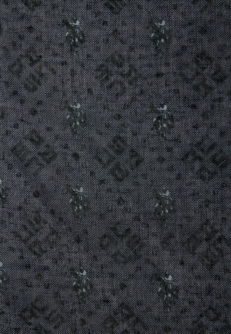 Ciemna, teksturowana tkanina z geometrycznym wzorem oraz subtelnymi, jaśniejszymi akcentami. Wzór zawiera różnorodne kształty i misternie wykończone detale.