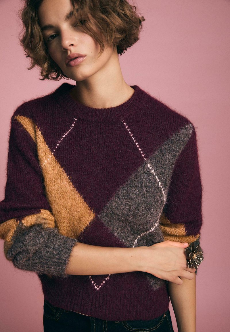 Maglione a maglia con motivo argyle nei colori bordeaux, giallo e grigio, con scollo tondo e maniche arrotolate, caratterizzato da una morbida texture e cuciture decorative.