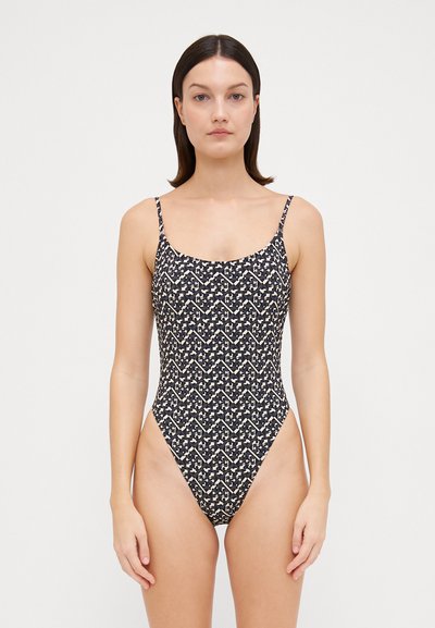 Black one-piece swimsuit with a geometric cream pattern, slim straps, and high-cut leg silhouette. Made from smooth fabric. No padding.