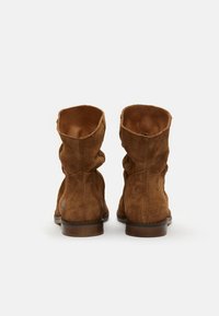 Botas de tobillo de ante marrón con un diseño arrugado; tacón plano; interior suave; parte superior abierta; detalles de costura mínimos.