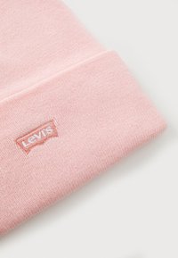 Ανοιχτό ροζ πλεκτό σκουφί με διπλωμένο χείλος, που διαθέτει ένα μικρό κεντημένο λογότυπο της Levi's σε ταιριαστό ροζ και λευκό νήμα.