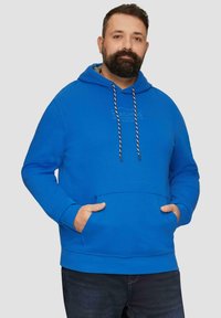 Niebieska bluza z kapturem, wykonana z miękkiego materiału, posiadająca przednią kieszeń kangurkę, regulowany kaptur z troczkami oraz subtelne logo. Posiada długie rękawy i luźny krój.
