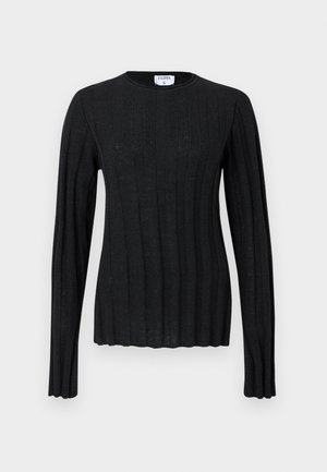 Svart ribbestrikket genser med lange ermer, rund hals, lett innsvinget silhuett og bølget kant nederst og på mansjettene.