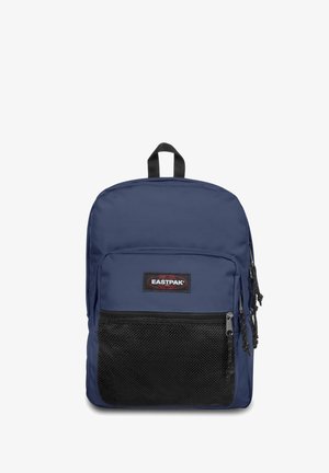 Mochila azul marino fabricada con un tejido duradero, con un bolsillo frontal de malla negra texturizada, parche con el logotipo y cremalleras negras. Incluye un asa superior para llevar.