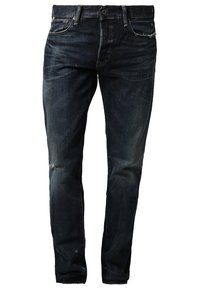 Tmavě modré džíny s úzkým střihem, mírně opotřebované na kolenou, design s pěti kapsami, kovový knoflík a zapínání na zip.