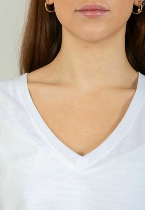 T-shirt blanc à encolure en V avec une texture douce et lisse. Présente un design classique avec un col modéré et des coutures nettes.