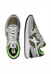 Sneaker grigie e verde oliva con tomaia in suede e tessuto, dettagli bianchi, suola in gomma nera e rivestimento verde neon. Design classico da corsa.