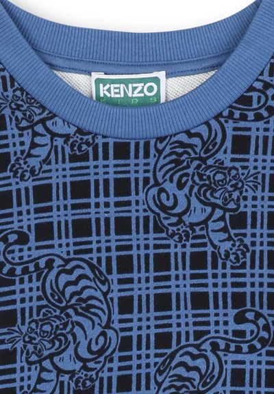 T-shirt en coton bleu avec un motif de tigre noir sur un design en grille géométrique. Col côtelé et texture douce. Étiquette Kenzo Kids visible.