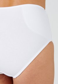 Braguita blanca de tiro alto hecha de una suave tela elástica. Presenta una textura lisa y detalles en la costura lateral, ideal para comodidad y cobertura.