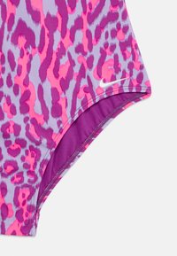 Lycra kopalke z vijoličnim in rožnatim leopardjim vzorcem. Ima vijolično notranjo oblogo in majhen bel Nike logotip na zunanjem robu.