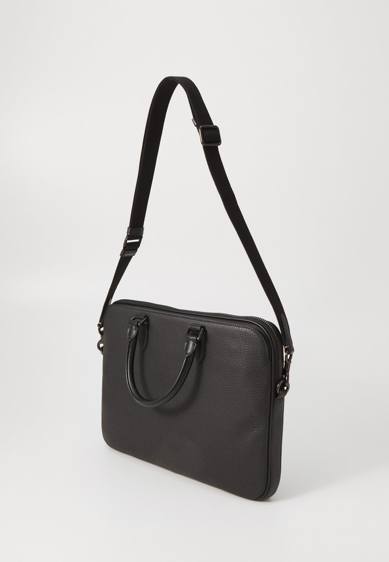 Borsa per laptop in pelle nera con superficie testurizzata, doppie maniglie corte e una tracolla rimovibile. Chiusura con zip lungo il bordo superiore.