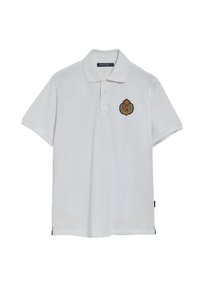 Vit polo med slät väv. Har en krage, tre knappar och en broderad logotyp på vänster bröst. Korta ärmar.