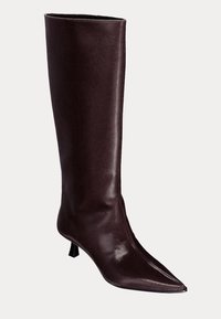 Botte en cuir marron foncé arrivant au genou avec un bout pointu et un petit talon aiguille angulaire, présentée sur un fond clair uni.