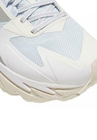 Scarpa sportiva azzurra chiara con tomaia in rete testurizzata, presenta una suola in gomma bianca con molte scanalature e dettagli riflettenti argentati.