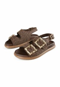 Sandalias trenzadas de color marrón con dos grandes hebillas doradas, diseño de punta abierta y parte superior texturizada. Suela de goma flexible para mayor comodidad.