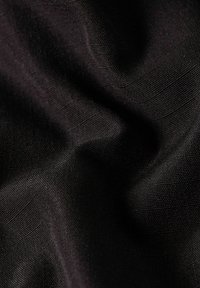 Black fabric with a fine, smooth texture, featuring subtle weave patterns and slight creases in a draped form.