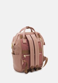 Różowy plecak wielokomorowy z podwójnymi uchwytami u góry, regulowanymi paskami, złotymi zamkami błyskawicznymi i teksturowanym wykończeniem z przodu.