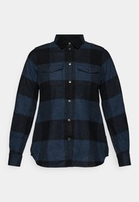 Donker geruite flanellen shirt met blauwe en zwarte kleuren, lange mouwen, knoopsluiting, twee borstzakken en een zachte textuur.