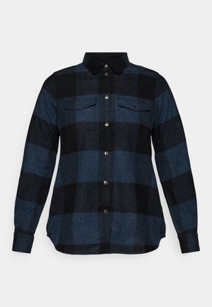 Donker geruite flanellen shirt met blauwe en zwarte kleuren, lange mouwen, knoopsluiting, twee borstzakken en een zachte textuur.
