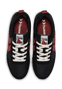 Czarne sneakersy z czerwonymi akcentami, z płaskimi białymi sznurówkami, tekstylną cholewką, wyściełanym kołnierzem i kontrastowym logo na języku. Lekka konstrukcja.