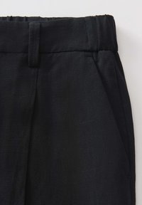 Black trousers with a textured finish, featuring a pleated design and elastic waistband for comfort and a tailored appearance.