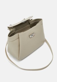 Borsa a tracolla beige con una finitura liscia e texture, dotata di chiusura a scatto in argento e cinturino regolabile. L'interno presenta diversi scomparti.