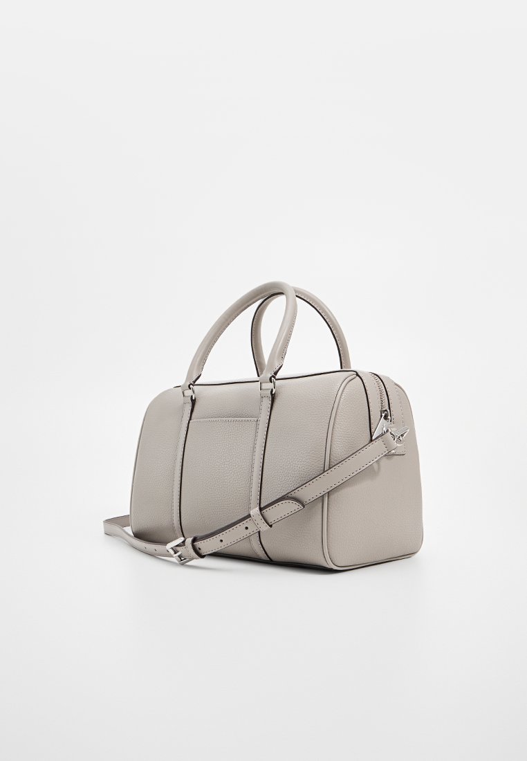 Sac à main en cuir gris clair avec doubles poignées et une bandoulière réglable, reposant sur une surface blanche.