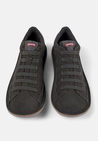 Scarpe da ginnastica nere con una superficie liscia, accenti texture e cinque paia di lacci piatti. Presentano una linguetta imbottita con etichetta del logo.