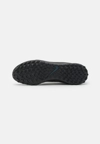 Schwarze Sportschuhsohle mit strukturiertem Gummi für Grip, stromlinienförmiger Form und einem kleinen blauen Logoakzent an der Seite.