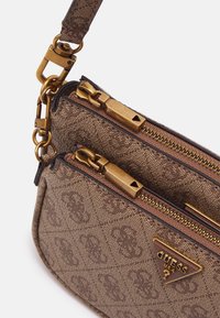 Brązowa torebka w wzory z dwoma zapinanymi na zamek przegrodami. Posiada złote okucia, trójkątne logo oraz odpinany pasek. Tkanina o fakturze.