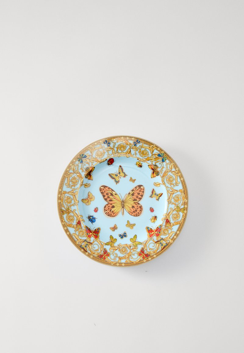 Niebieski porcelanowy talerz ze złotą kwiatową obwódką, na którym w centrum znajdują się różnokolorowe motyle i owady. Błyszcząca powierzchnia z misternym wzorem.