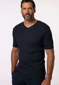 T-shirt a maniche corte blu navy con scollo a V in tessuto rigato, caratterizzato da una vestibilità rilassata e dettagli di cucitura discreti lungo il collo e l'orlo.