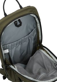 Ανοιχτό σακίδιο πλάτης σε ελαιώδες πράσινο χρώμα που αποκαλύπτει το γκρι εσωτερικό του με ελαστική τσέπη και δίχτυνο διαμερισμό με φερμουάρ για οργανωμένη αποθήκευση.