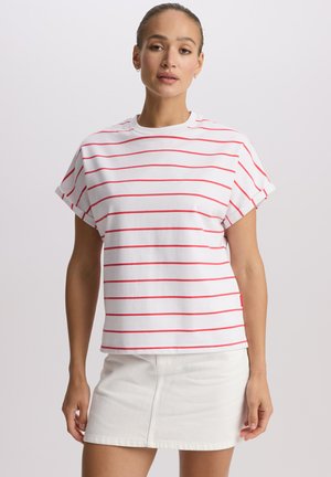 Biały t-shirt z krótkim rękawem i czerwonymi poziomymi paskami, z okrągłym dekoltem i podwiniętymi mankietami, zestawiony z białą denimową spódnicą.