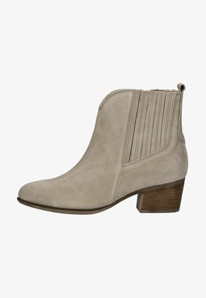 Stivale alla caviglia in suede beige con punta arrotondata, pannelli elasticizzati sui lati e un tacco in legno impilato. Presenta una cucitura sottile e una texture liscia.