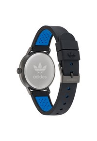Bracelet en silicone noir avec des accents bleus, boîtier en acier inoxydable argenté, cadran rond, logo Adidas au dos, bracelet texturé et perforations pour la respirabilité.