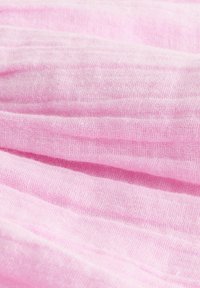 Soft pink fabric with fine, loosely woven texture and gentle folds creating subtle shadows and highlights.