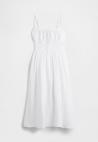 Vit maxiklänning i texturerat tyg med tunna justerbara axelband, resår i midjan och en luftig kjol. Mjukt, lätt material.