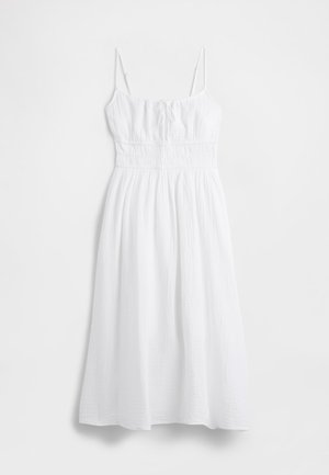 Weißes Maxikleid aus strukturiertem Stoff mit dünnen, verstellbaren Trägern, geraffter Taille und einem fließenden Rock. Glattes, leichtes Material.